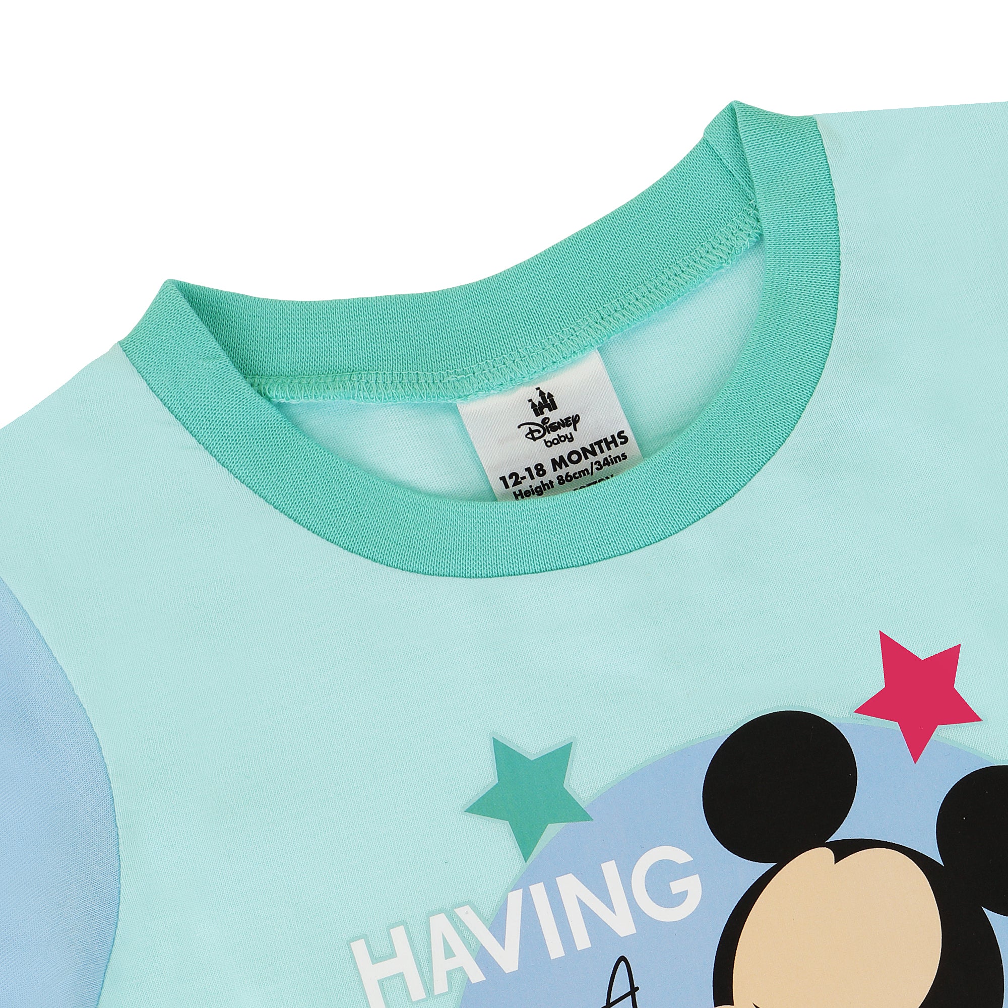 Close-up of a children's outfit with a Disney label, featuring a character and stars on a light blue background.