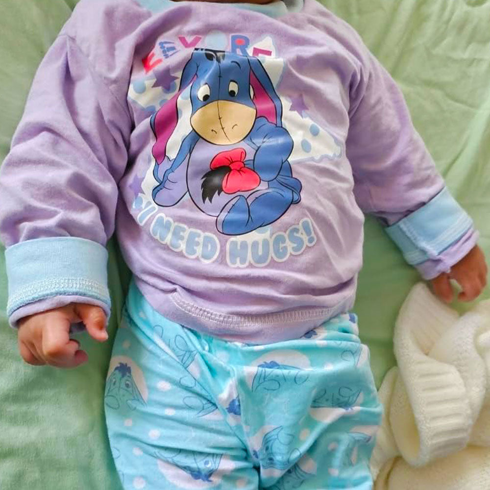 Baby wearing Disney Eeyore Baby Toddler Outfit on a green blanket.