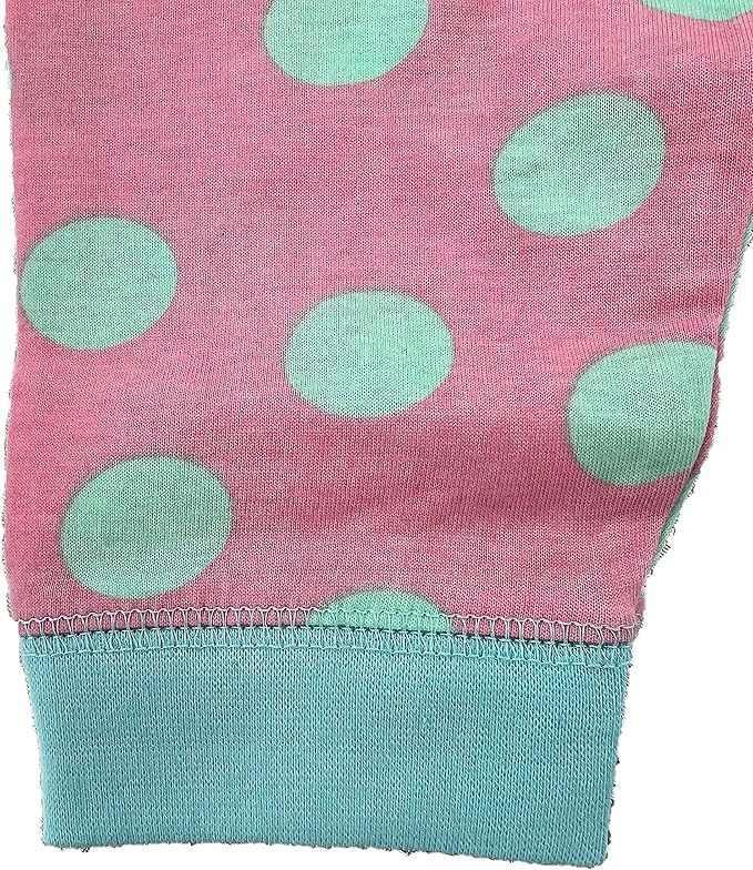 Disney Baby 101 Dalmations Close-up of pink fabric with green polka dots and a blue hem.