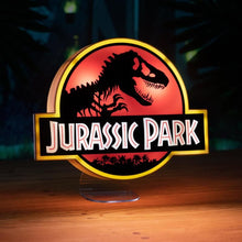 Load image into Gallery viewer, Jurassic Park Logo Light illumnted and sitting wooden desk wiht Jungle background

